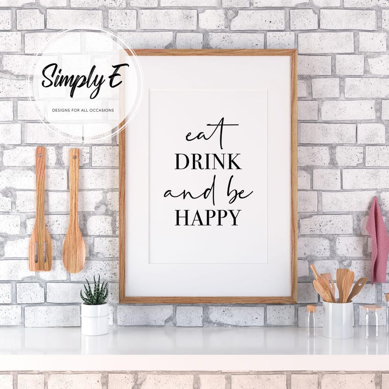 Peut inclure: Une impression encadr&eacute;e avec le texte "eat DRINK and be HAPPY" en lettres noires sur fond blanc. L'impression est accroch&eacute;e &agrave; un mur en briques blanches.