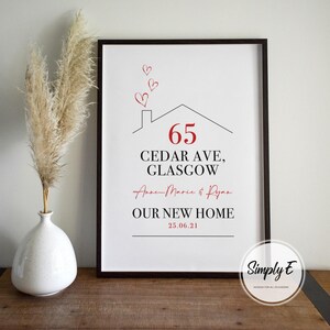 Peut inclure: Impression encadr&eacute;e avec un cadre noir. Elle pr&eacute;sente un dessin de maison, le num&eacute;ro 65 en rouge, et le texte "CEDAR AVE, GLASGOW". Elle comprend &eacute;galement des noms, "NOTRE NOUVELLE MAISON" et une date. Des c&oelig;urs rouges sont au-dessus.