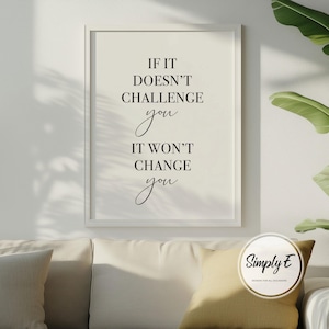 Może przedstawiać: Oprawiony wydruk z napisem "IF IT DOESN'T CHALLENGE you IT WON'T CHANGE you" czcionką w kolorze czarnym. Wydruk jest w białej ramie i wisi nad kremową sofą z ż&oacute;łtą poduszką. Logo "Simply E" znajduje się w prawym dolnym rogu.