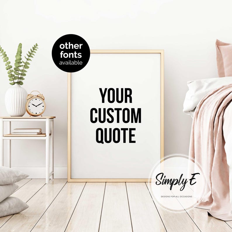 K&ouml;nnte beinhalten: Ein gerahmter Druck mit dem Text "YOUR CUSTOM QUOTE" in fetter, schwarzer Schrift. Der Rahmen ist goldfarben. Links befindet sich ein kleiner Tisch mit einer Vase, einer Uhr und B&uuml;chern. Das Bild enth&auml;lt auch den Text "other fonts available" und das Logo "Simply E".
