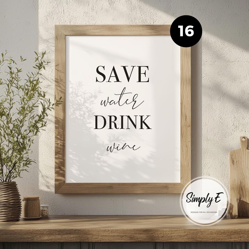 May include: A framed wall art print featuring the black text SAVE water DRINK wine on a white background. The frame is made of light-toned wood. The design is presented in a clean, minimalist style with a mix of bold serif and script fonts.