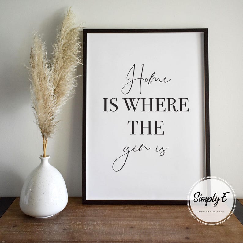 May include: A white ceramic mug with a black handle and the text "But First, Coffee" in a bold, black font. The mug is set against a blurred background, suggesting a cozy setting.