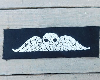 Parche de calavera y alas de lápida