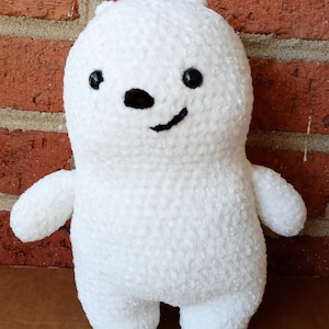 May include: White crocheted plush toy shaped like a bear with black eyes and a black nose. The bear has a smiling expression.