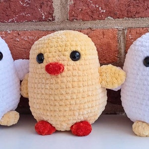 Puede incluir: Tres pollos de peluche tejidos a crochet. Uno es blanco con una cresta roja, otro es amarillo y el &uacute;ltimo es blanco. Todos tienen ojos negros y un peque&ntilde;o pico naranja.