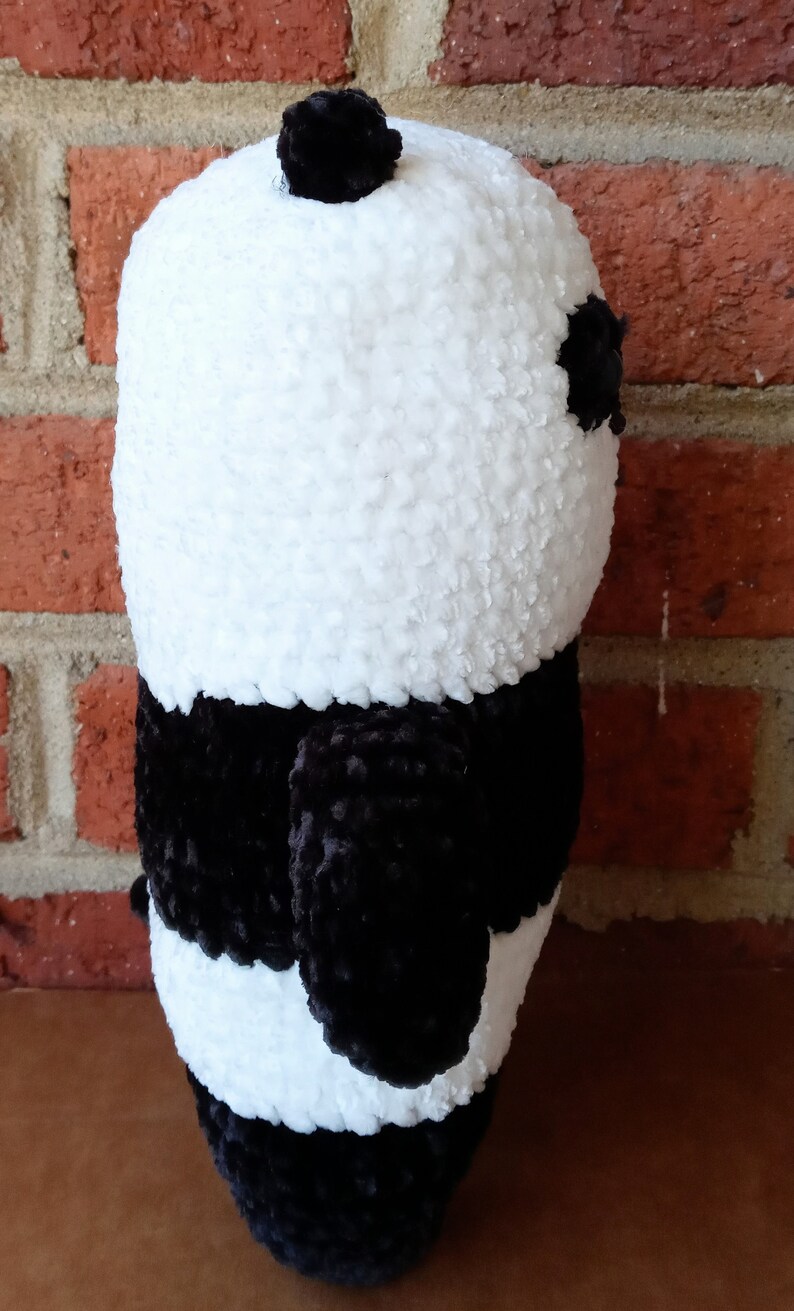 May include: A black and white crocheted panda plush toy. The panda has a black nose and eyes and a black pom-pom on its head.