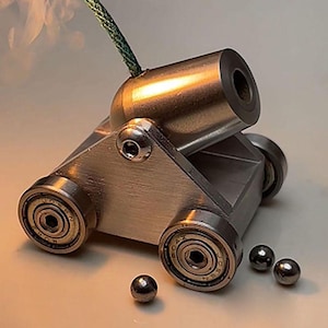 Mini modelo de cañón de metal vintage: objeto de colección artesanal y elegante decoración de escritorio.