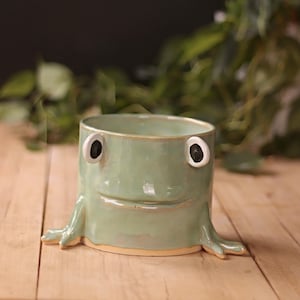 May include: A set of three ceramic mugs with a speckled, matte finish. Each mug features a different color: light blue, cream, and gray. The mugs have a simple, modern design and a comfortable handle.