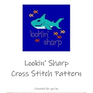 Puede incluir: Patrón de punto de cruz para un tiburón con el texto "lookin' sharp" y pequeños peces a su alrededor. El patrón está creado por The Nerdy Mama's Craft Corner.