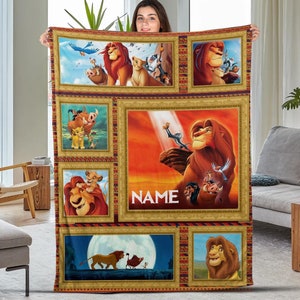 May include: A colorful fleece blanket with a collage of images from the movie The Lion King. The blanket features Simba, Mufasa, Nala, Pumbaa, and Timon in various scenes from the movie. The blanket is personalized with the word "NAME" in a gold frame.