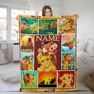 May include: A yellow and orange blanket featuring various scenes and characters from The Lion King. The blanket has a collage design with images of Simba, Timon, Pumbaa, and other characters. The word "NAME" is displayed in gold letters.