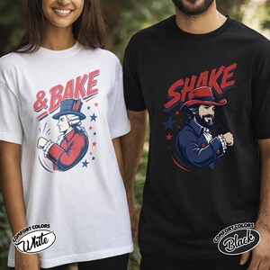 May include: A white t-shirt featuring a graphic of a historical figure in a red coat and blue hat with the text & BAKE, and a black t-shirt featuring a graphic of a bearded figure in a blue coat and red hat with the text SHAKE, both with stars.