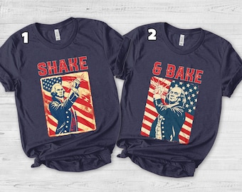 May include: Two navy blue t-shirts with patriotic designs. One shirt says "SHAKE" above an image of a man with a flag background. The other says "& BAKE" above a similar image. Both shirts have a vintage, distressed look.