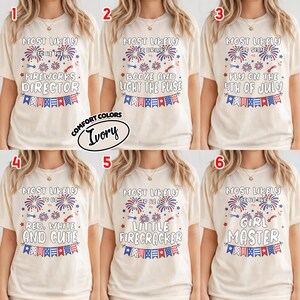 May include: Six ivory t-shirts featuring red, white, and blue firework graphics and bunting. Each shirt displays unique text: Most Likely To Be The Fireworks Director, Booze And Light The Fuse, Stay Fly On The 4th Of July, Red, White And Cute, A Little Firecracker, or Girl Master.