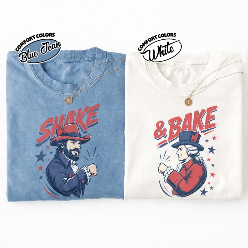 May include: Two t-shirts, one blue jean and one white, each featuring a graphic print. The blue shirt displays a man in a red hat with the text SHAKE. The white shirt displays a man in a colonial hat with the text & BAKE. Both include stars.