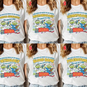 May include: White t-shirts with various medical lab-themed designs. Each shirt features a cartoon alien doctor with lab equipment and the word "CREW" below. The designs include "Clinical Chemistry", "Microbiology", "Hematology", "Pathology", "Blood Bank", and "Phlebotomy".