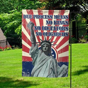 May include: A garden flag featuring the Statue of Liberty with a red, white, and blue background. The flag displays the text "DUE PROCESS MEANS NO KINGS NO DICTATORS NO OLIGARCHS."