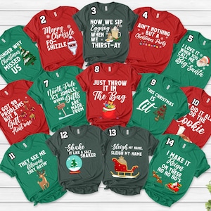 May include: A set of 14 green and red Christmas t-shirts with various holiday-themed sayings. The shirts feature a variety of designs, including a snowman, a Christmas tree, and a Santa Claus. The text on the shirts includes phrases like "Wonder Why Christmas Missed Us", "Merry Chrizzle Fo-Shizzle", "Now We Sip Eggnog When We Thirst-Ay", "Ain't Nothing But A Christmas Party", "I Love It When You Call Me Big Santa", "I Got 99 Problems But A Gift Ain't One", "North Pole Icy Jungle Where Gifts Are Made From", "Just Throw It In The Bag", "This Christmas Is Lit", "Did It All For The Cookie", "They See Me Glowin They Hatin", "Shake It Like A Salt Shaker", "Sleigh My Name Sleigh My Name", and "I Make It Reign On These Ho Ho Ho's".