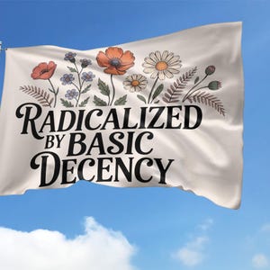May include: A white flag with the text "RADICALIZED BY BASIC DECENCY" in black script. The top of the flag features a floral design with orange poppies, daisies, and other flowers. The flag is waving against a blue sky.