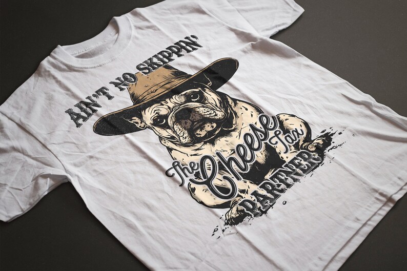 May include: White t-shirt featuring a bulldog wearing a cowboy hat. The graphic includes the text "Ain't No Skippin'" above the dog and "The Cheese Tax Partner" below. The design is in black and tan.
