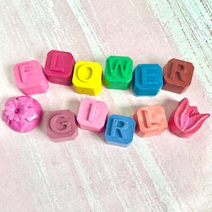 May include: A set of colorful alphabet blocks spelling out "FLOWER GIRL" with two additional blocks depicting a flower and a tulip.