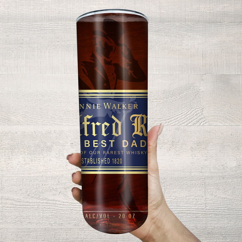 May include: A brown and gold 20 ounce tumbler with a Johnnie Walker label. The label has a gold design with the text "fred R BEST DAD OF OUR RAREST WHISKY ESTABLISHED 1820".