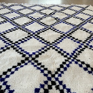May include: White, blue, and black Moroccan rug with a geometric diamond pattern.