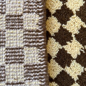 May include: Close-up of two different textured fabrics. One fabric is a brown and white checkered pattern, the other is a brown and white striped pattern.