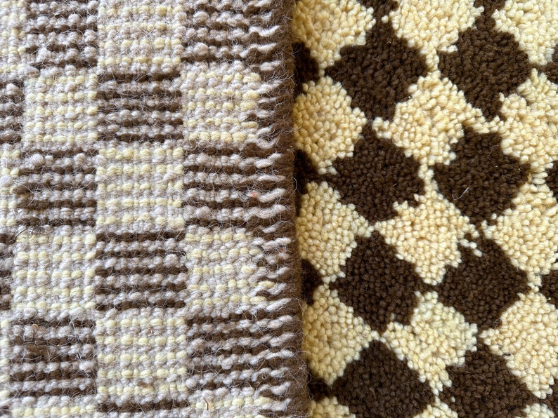 May include: Close-up of two different textured fabrics. One fabric is a brown and white checkered pattern, the other is a brown and white striped pattern.