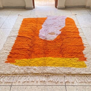 Handwoven Beni Ourain rug in rich orange color adding warmth and energy to a minimalist room