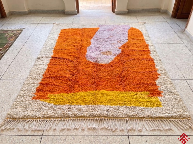 Handwoven Beni Ourain rug in rich orange color adding warmth and energy to a minimalist room