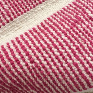 May include: Close-up of a textured rug with a repeating pattern of alternating white and magenta stripes. The rug appears to be made of woven material, with a soft, tactile appearance. The design is simple yet visually appealing.