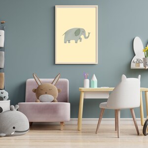 May include: A light blue wall with a pink armchair, a white chair, a wooden desk, and a white shelf with a bunny rabbit design. The wall has a framed print of a grey elephant with a yellow background. There are also storage bins with animal faces on the wall.