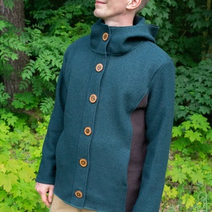 May include: A dark green hooded jacket with brown accents and wooden buttons. The jacket is made of a soft, textured fabric.