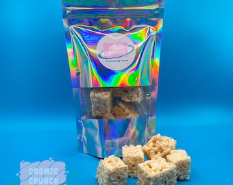 May include: A bag of freeze-dried treats called "Cosmic Crunch" with a holographic iridescent finish. The bag is open and several white, square-shaped treats are spilling out.