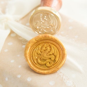 Peut inclure: Un colis en papier brun à pois blancs est attaché avec un ruban blanc. Deux sceaux de cire dorés avec un motif de dragon sont sur le colis.