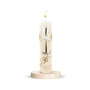 May include: A white candle with a gold cross and two white hearts on it. The candle is on a wooden base. The candle is decorated with doves and a ring.