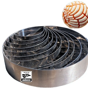 May include: A set of 10 stainless steel concha cutters, designed to create the traditional Mexican sweet bread. The cutters are arranged in a circle, with the largest cutter at the bottom and the smallest cutter at the top. The cutters are made in Mexico, as indicated by the label on the bottom of the set.