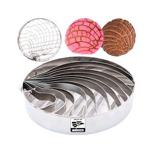May include: A stainless steel concha mold with a circular shape and a series of concentric rings. The mold is designed to create the traditional Mexican sweet bread known as concha. The mold is made in Mexico, as indicated by the label "Hecho en Mexico".