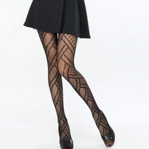 May include: Black patterned tights with a geometric design are worn with a black skirt and black peep-toe heels with red soles. The tights feature a diamond and crisscross pattern.