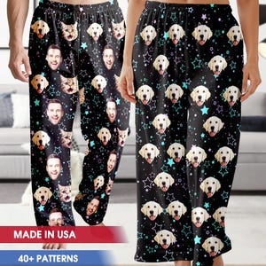 May include: Black pajama pants with a repeating pattern of smiling faces, cat faces, dog faces, and stars. The text "MADE IN USA" and "40+ PATTERNS" are visible at the bottom of the image.