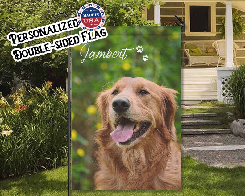 May include: A double-sided garden flag with a golden retriever dog. The flag displays the name "Lambert" in script, paw prints, and the text "Personalized Double-Sided Flag" and "Made in USA". The dog has a pink tongue and is set against a green background.