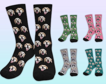 May include: A set of six pairs of colorful socks featuring a repeating pattern of dog faces. The socks are black, green, pink, and gray.