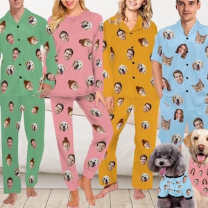 May include: Four sets of pyjamas in green, pink, yellow, and light blue, each featuring a repeating pattern of human and dog faces. The light blue set includes short sleeves and shorts, while the others have long sleeves and trousers. A dog wears a matching bandana.