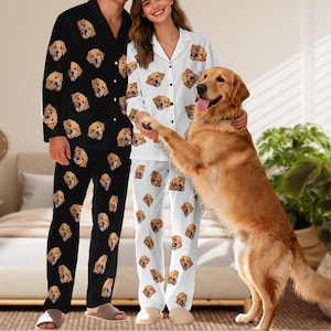 May include: A set of two-piece pyjamas featuring a repeating pattern of golden retriever faces. One set is black with white buttons and a collared top, while the other set is white with black buttons and a collared top, both with matching trousers.