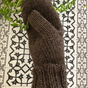 Pu&ograve; includere: Un guanto di lana marrone con polsino a coste. Il guanto &egrave; realizzato in un filato morbido e caldo, perfetto per mantenere le mani al caldo in inverno.