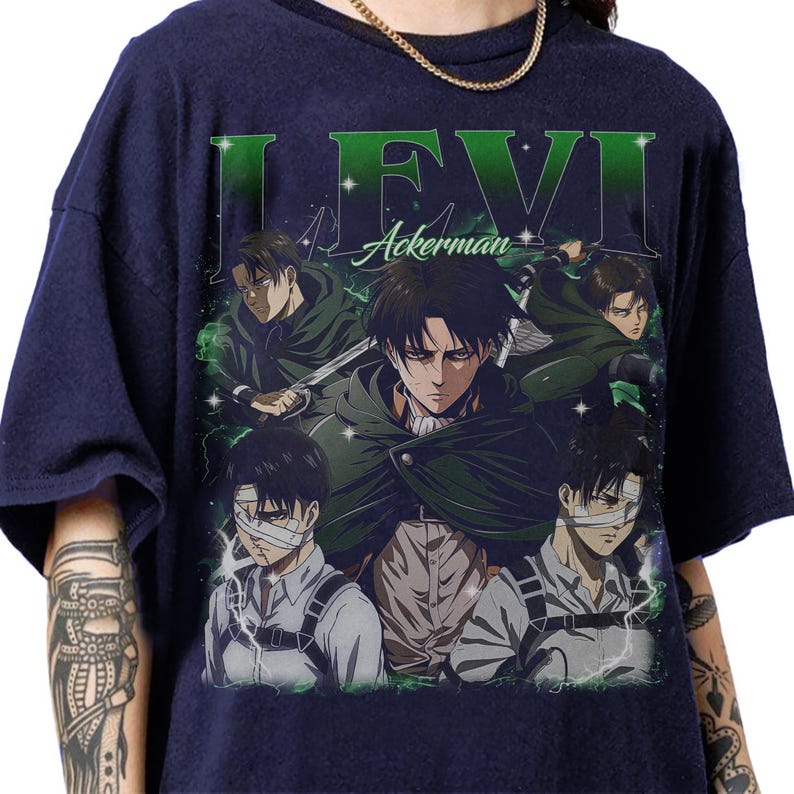 May include: Navy blue t-shirt with a graphic design from the anime series Attack on Titan. The design features the name "LEVI Ackerman" in green, and multiple illustrations of the character. The shirt has a vintage, distressed appearance.