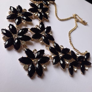 Collar babero floral negro y brillante