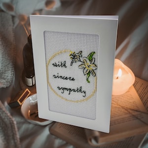 Avec une carte de point de croix de sympathie sincère