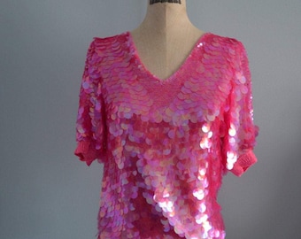 Blusa Oleg Cassini rosa com lantejoulas e modelagem redonda.